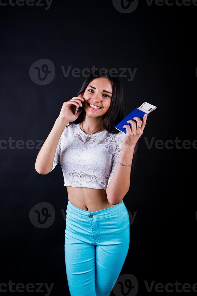 Portrait of a happy woman posing with passport and smartphone. photo