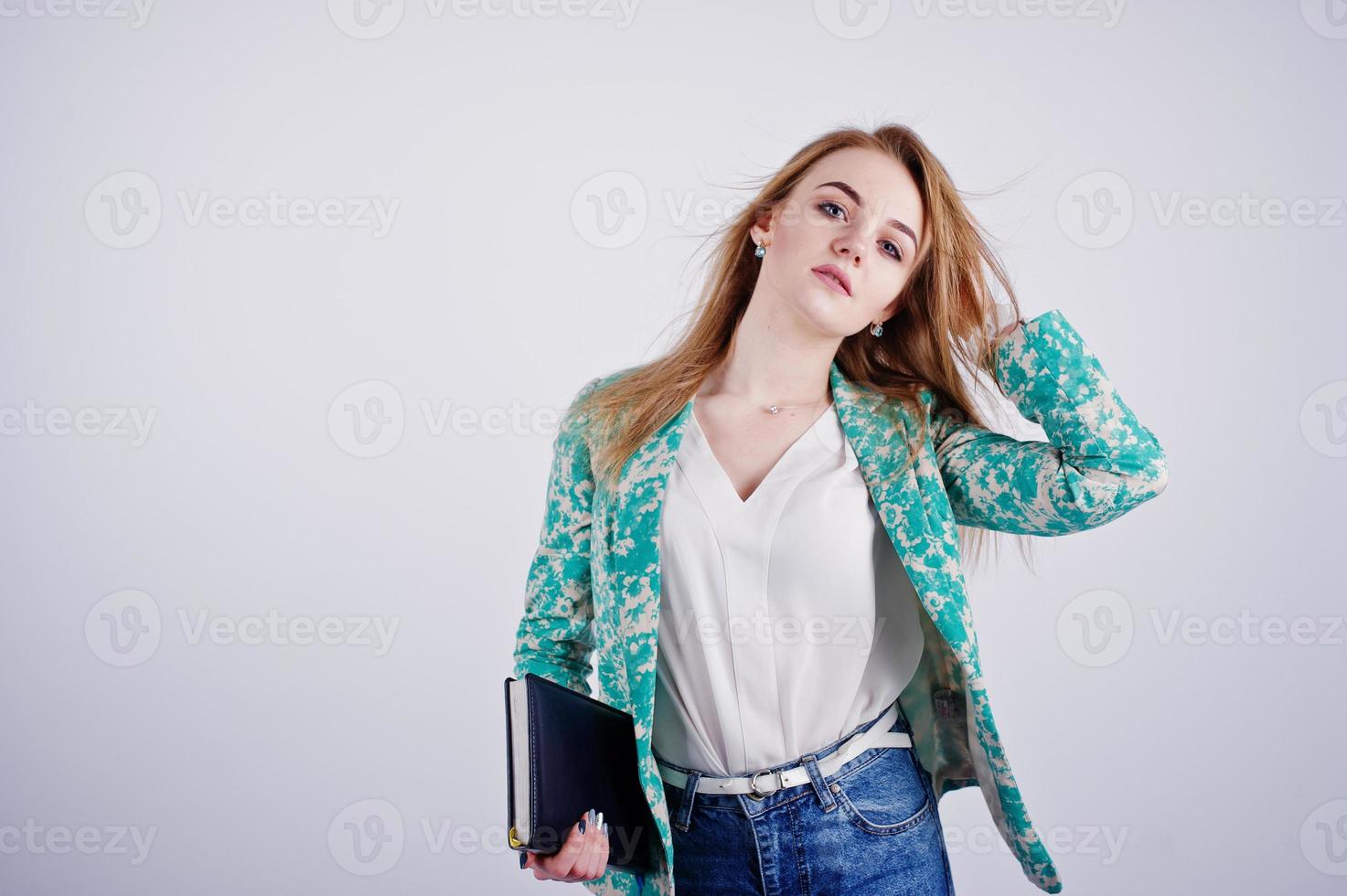 Stylish blonde girl in jacket and jeans with notebook diary at hands against white background on studio. photo