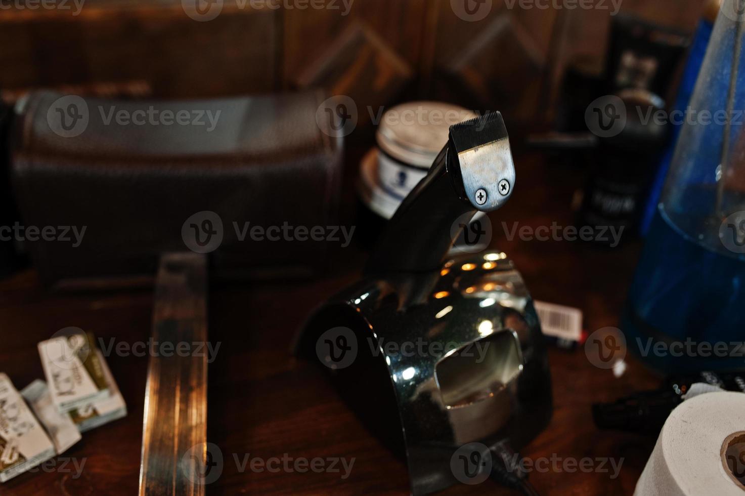 herramientas de peluquero sobre mesa de fondo de madera con máquinas eléctricas. foto