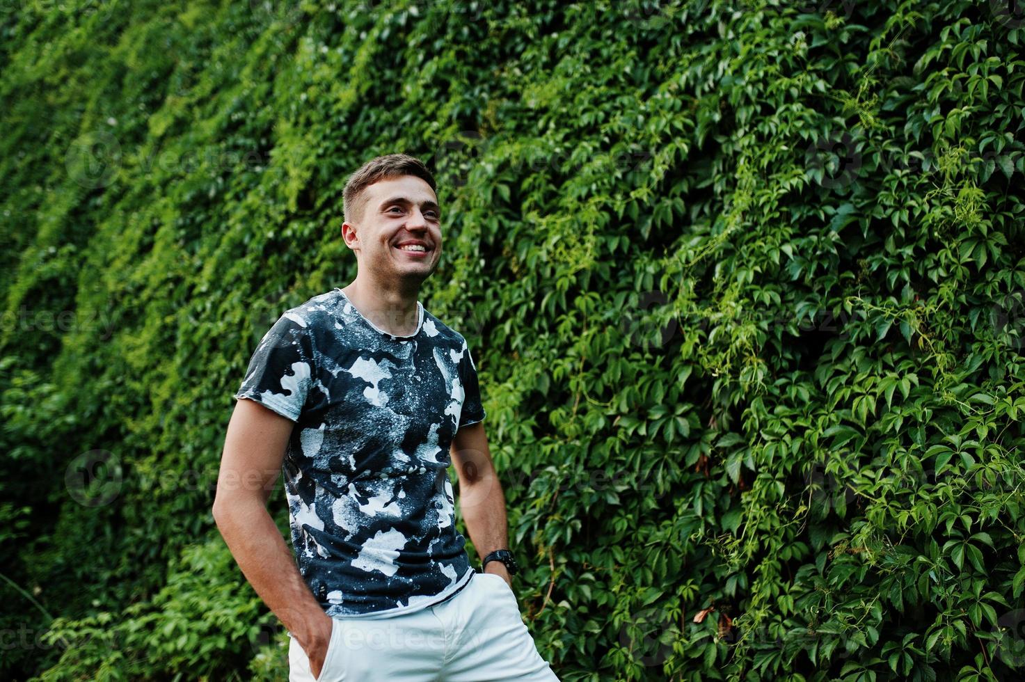 retrato de estilo de vida de un hombre guapo posando contra una pared verde. foto