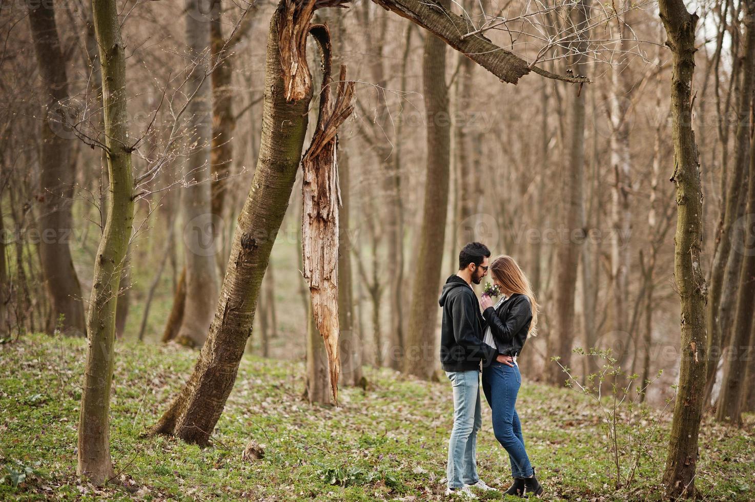 Love story of cool multiracial couple in spring forest. photo