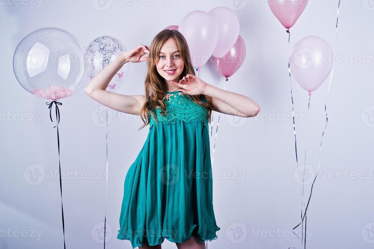 Happy girl in green turqoise dress with colored balloons isolated on white. Celebrating birthday theme. photo