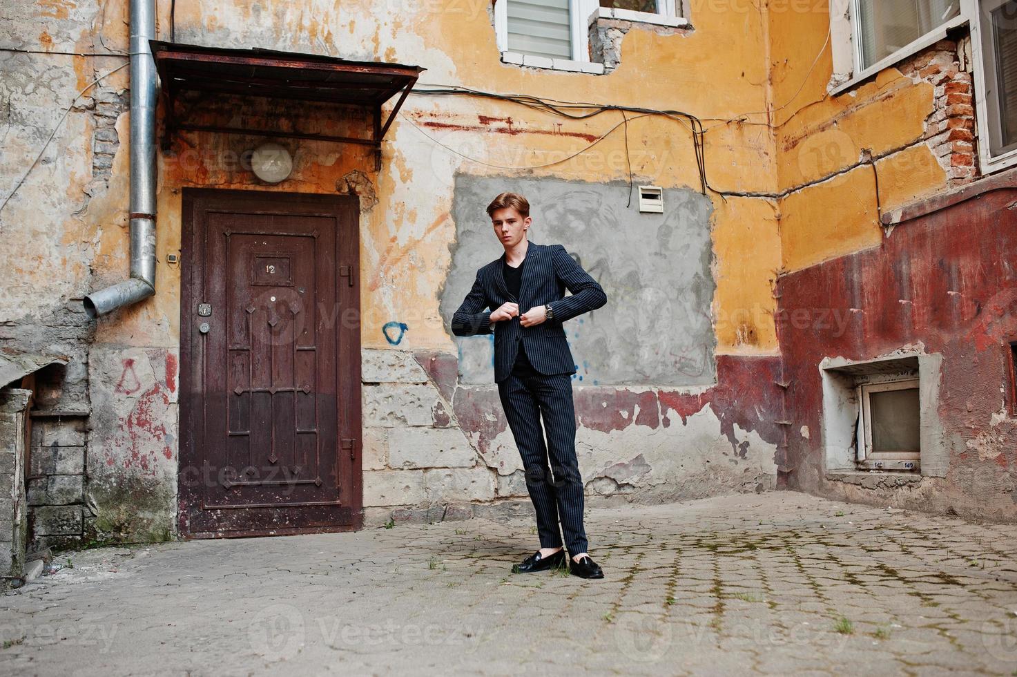 joven macho con estilo en chaqueta negra planteada al aire libre de la calle. increíble modelo de hombre. foto