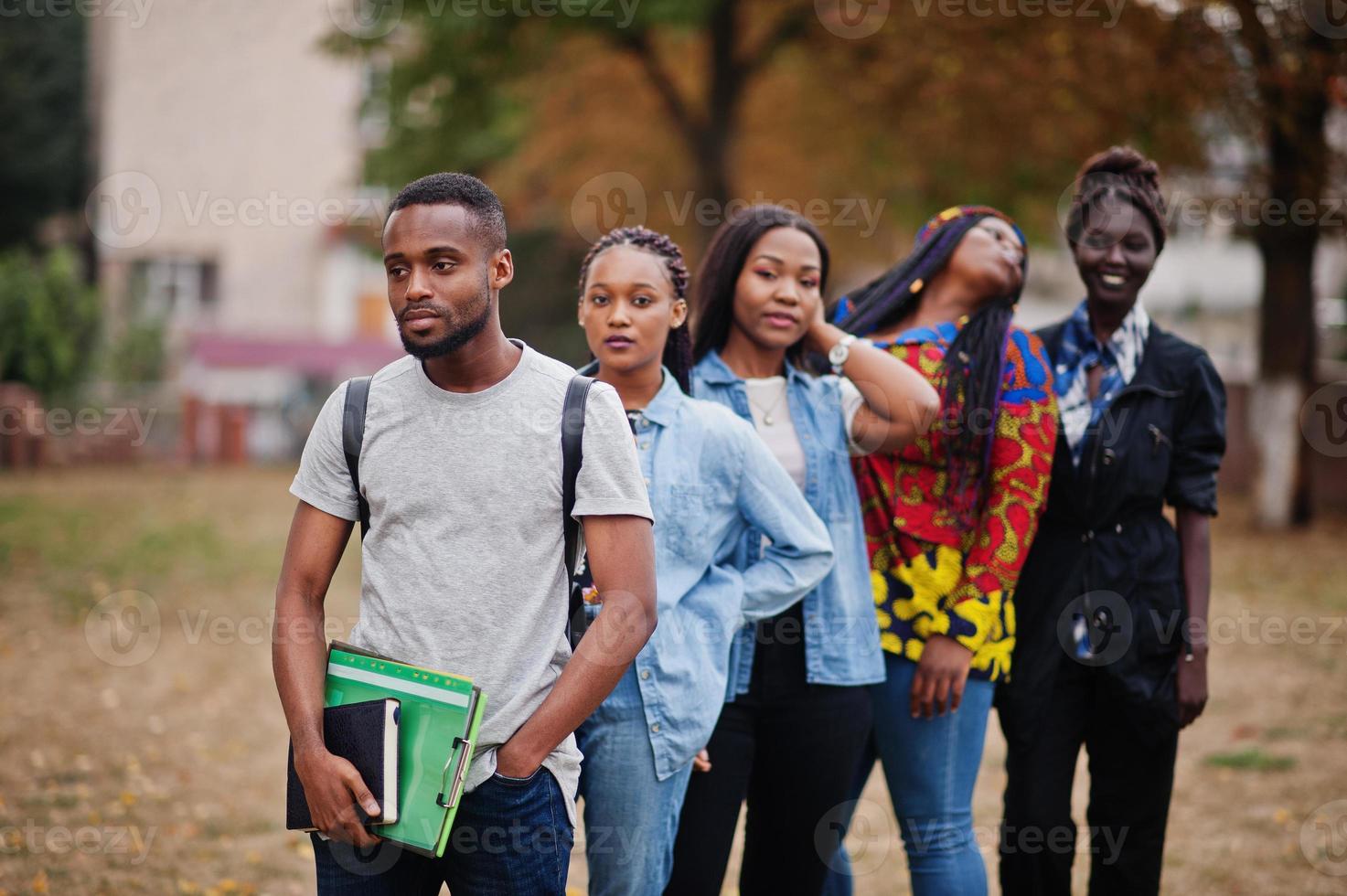Row of group five african college students spending time together on campus at university yard. Black afro friends studying. Education theme. photo