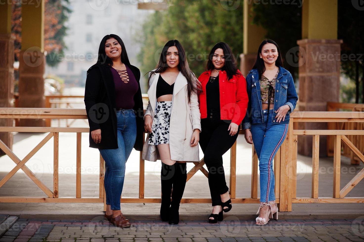 Group of four happy and pretty latino girls from Ecuador posed at street. photo