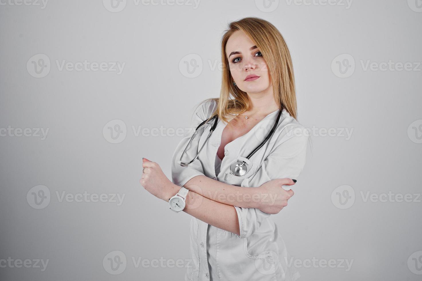 Blonde sexy doctor nurse with stethoscope isolated on white background. photo