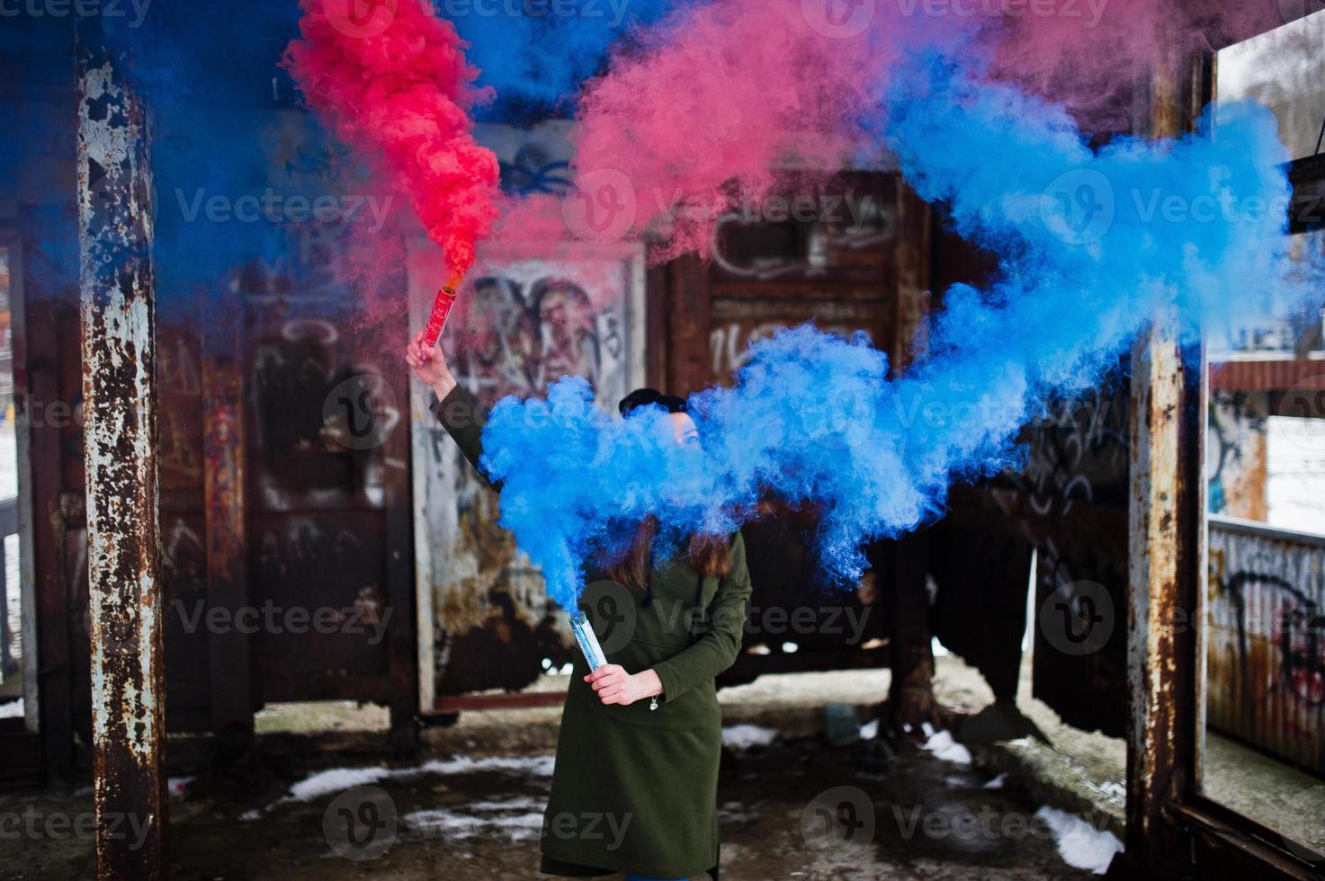 Young girl with blue and red colored smoke bomb in hands. photo