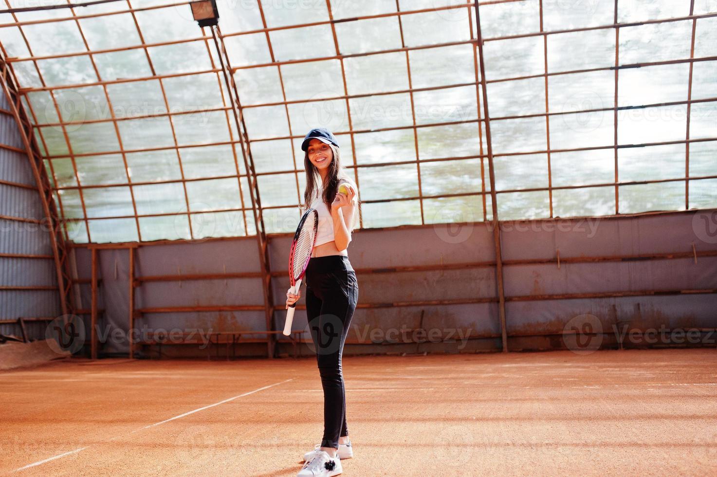 Young sporty girl player with tennis racket on tennis court. photo