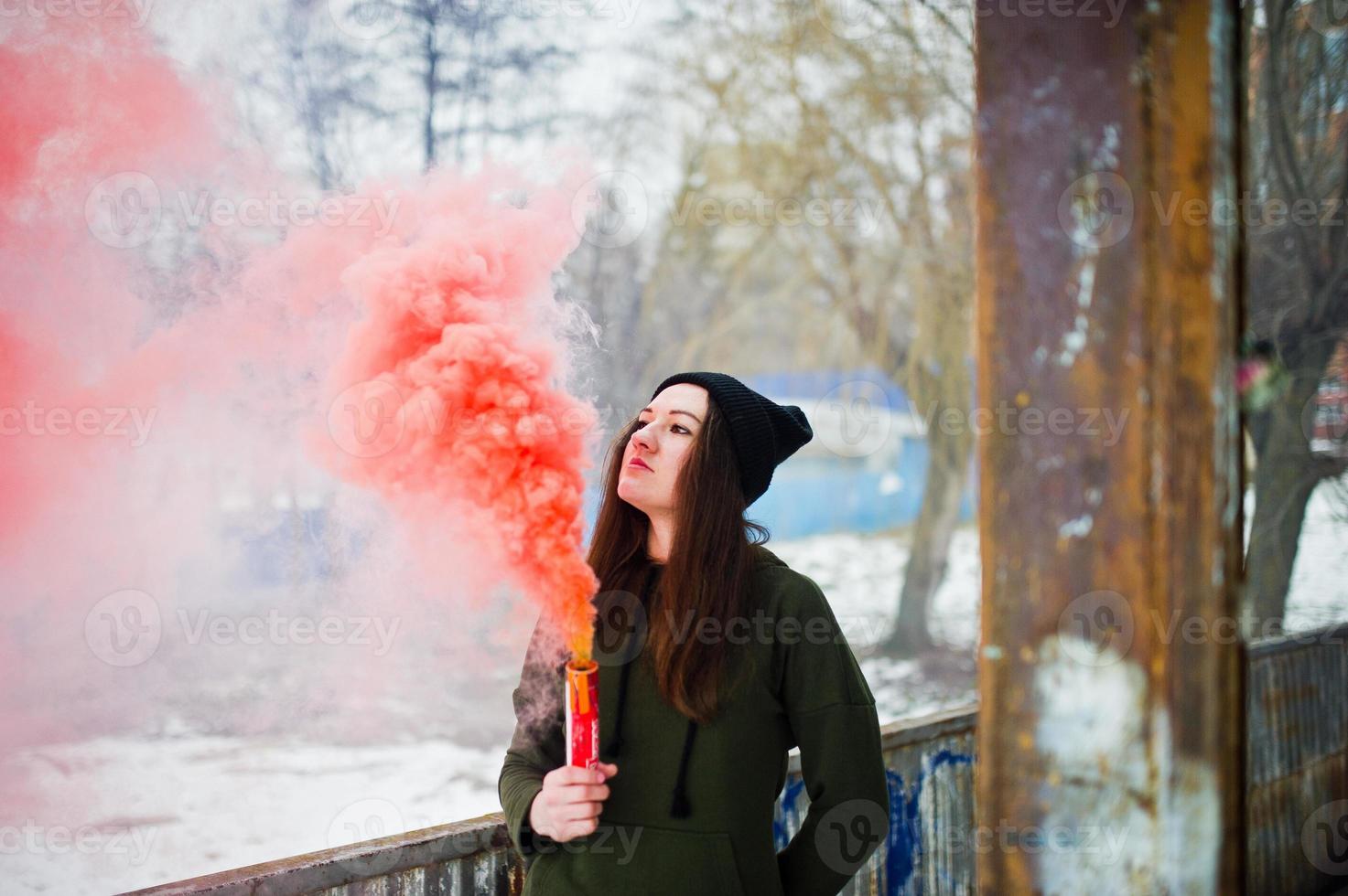 Young girl with red colored smoke bomb in hand. photo