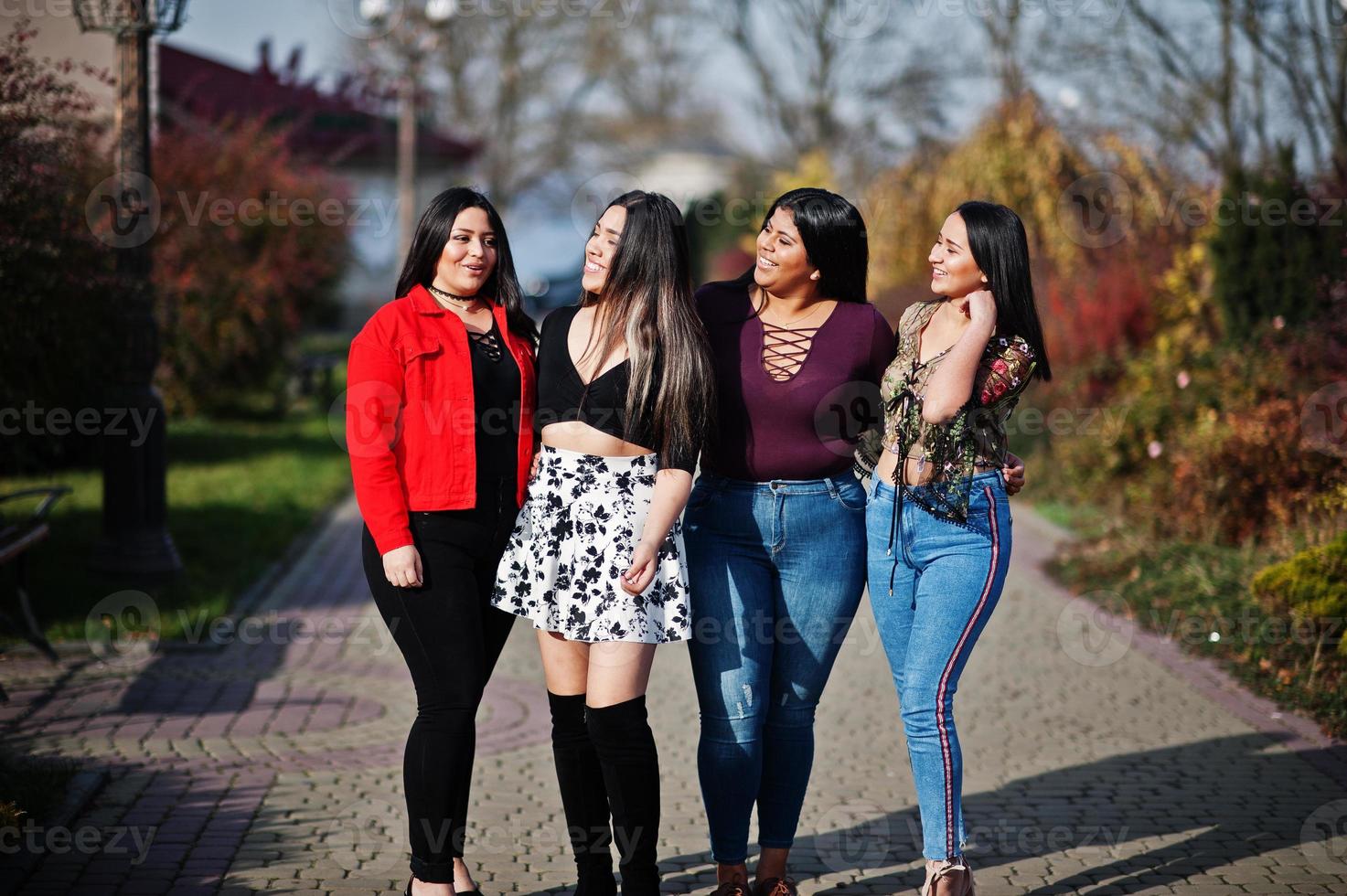 Group of four happy and pretty latino girls from Ecuador posed at street. photo