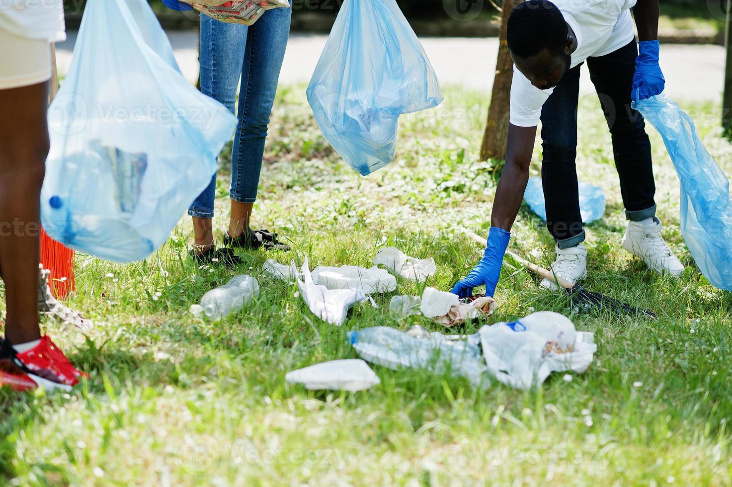 grupo de voluntarios africanos felices con área de limpieza de bolsas de basura en el parque. Concepto de voluntariado, caridad, personas y ecología de África. foto