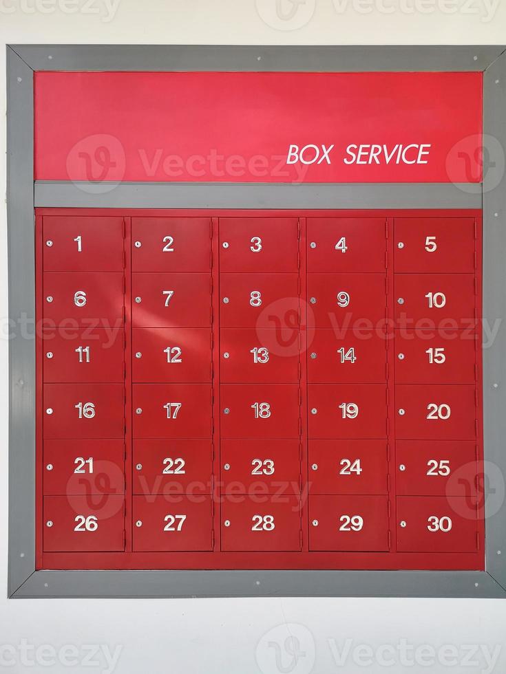 post office mailbox box service screen white text number one to thirty on front red steel with key Mortise lock, strack in the row photo