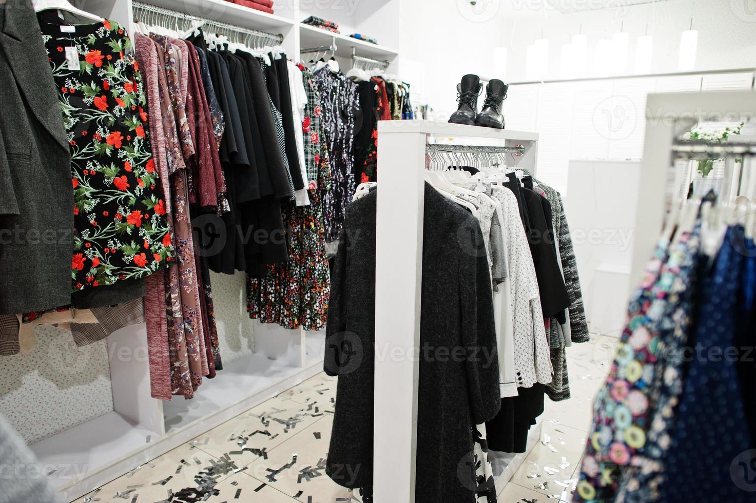 Female colorful clothing set of on the racks with shoes in clothing store brand new modern boutique. photo