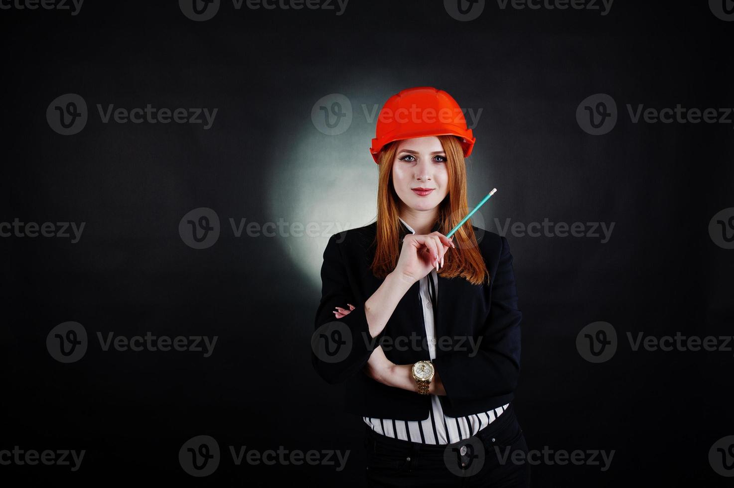 Engineer woman in orange protect helmet with pensil. photo