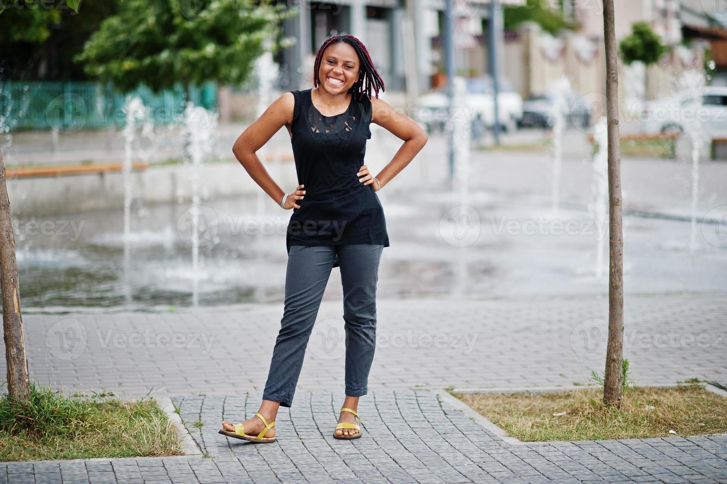 Young african american woman posed against fountain. photo