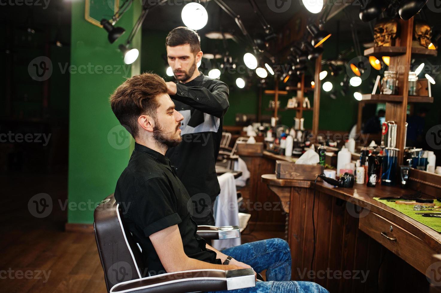 Handsome bearded man at the barbershop, barber at work. photo
