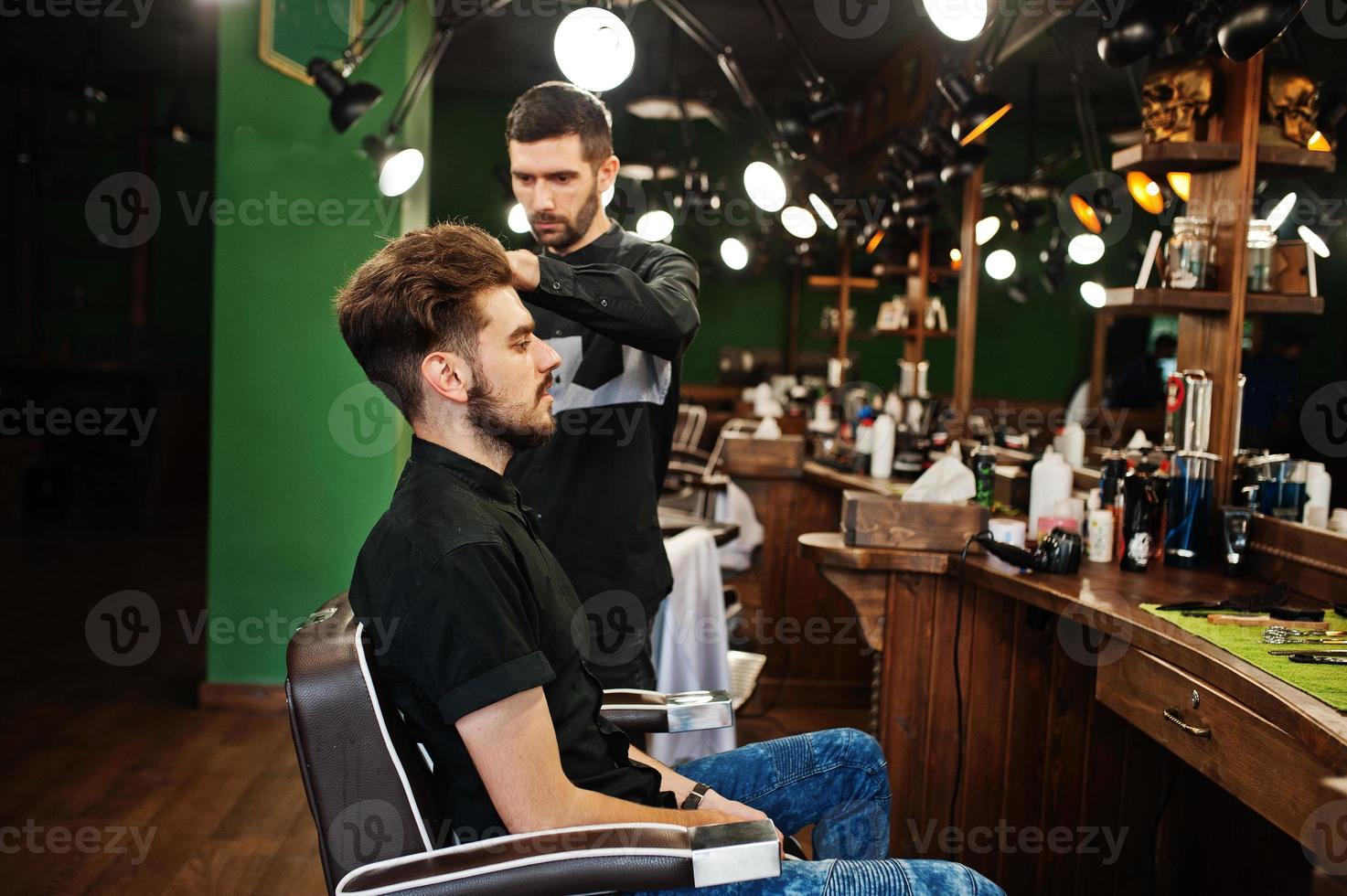 apuesto hombre barbudo en la barbería, peluquero en el trabajo. foto