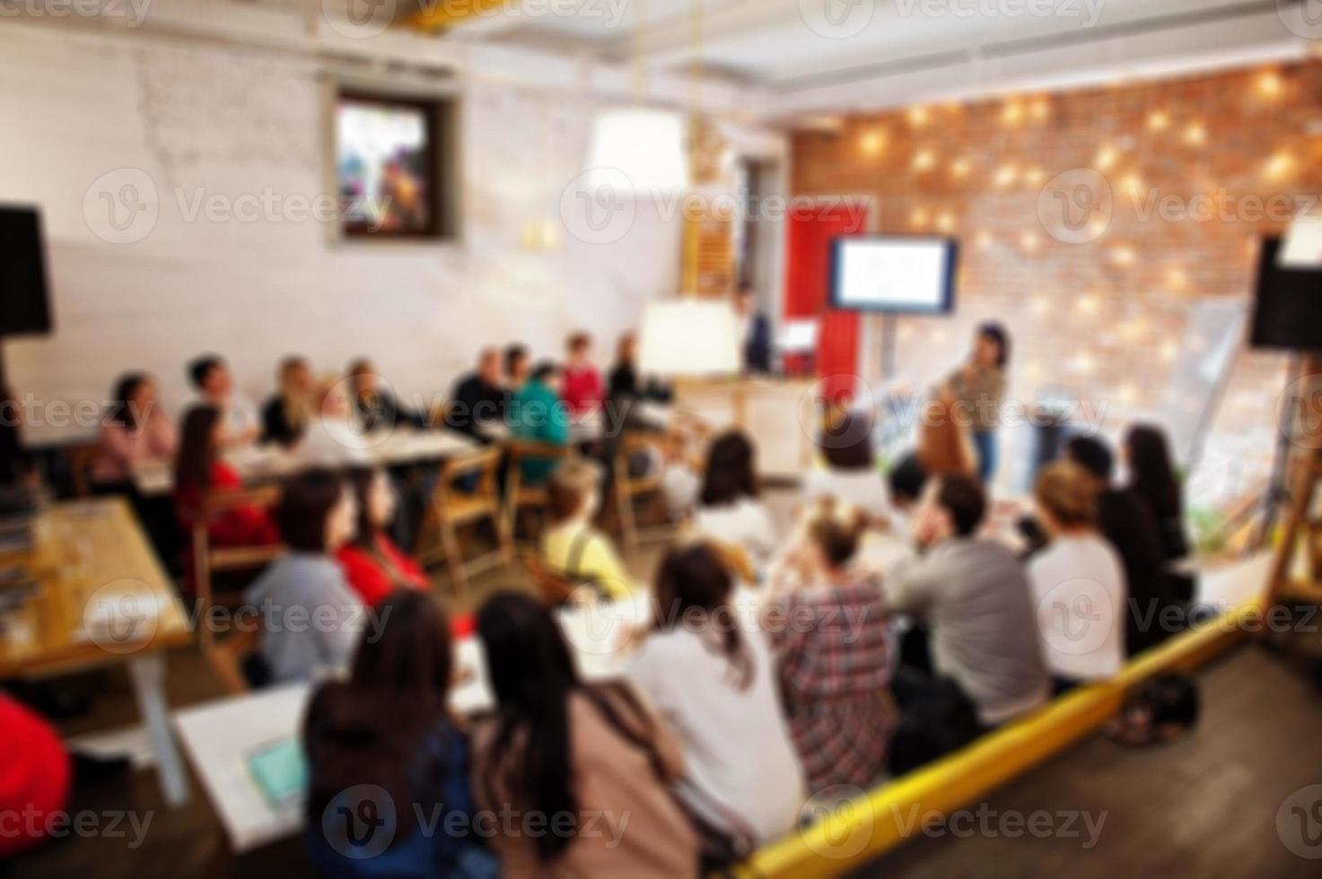 Master class and study concept. Abstract blurred photo of conference or seminar room with speaker on the stage.