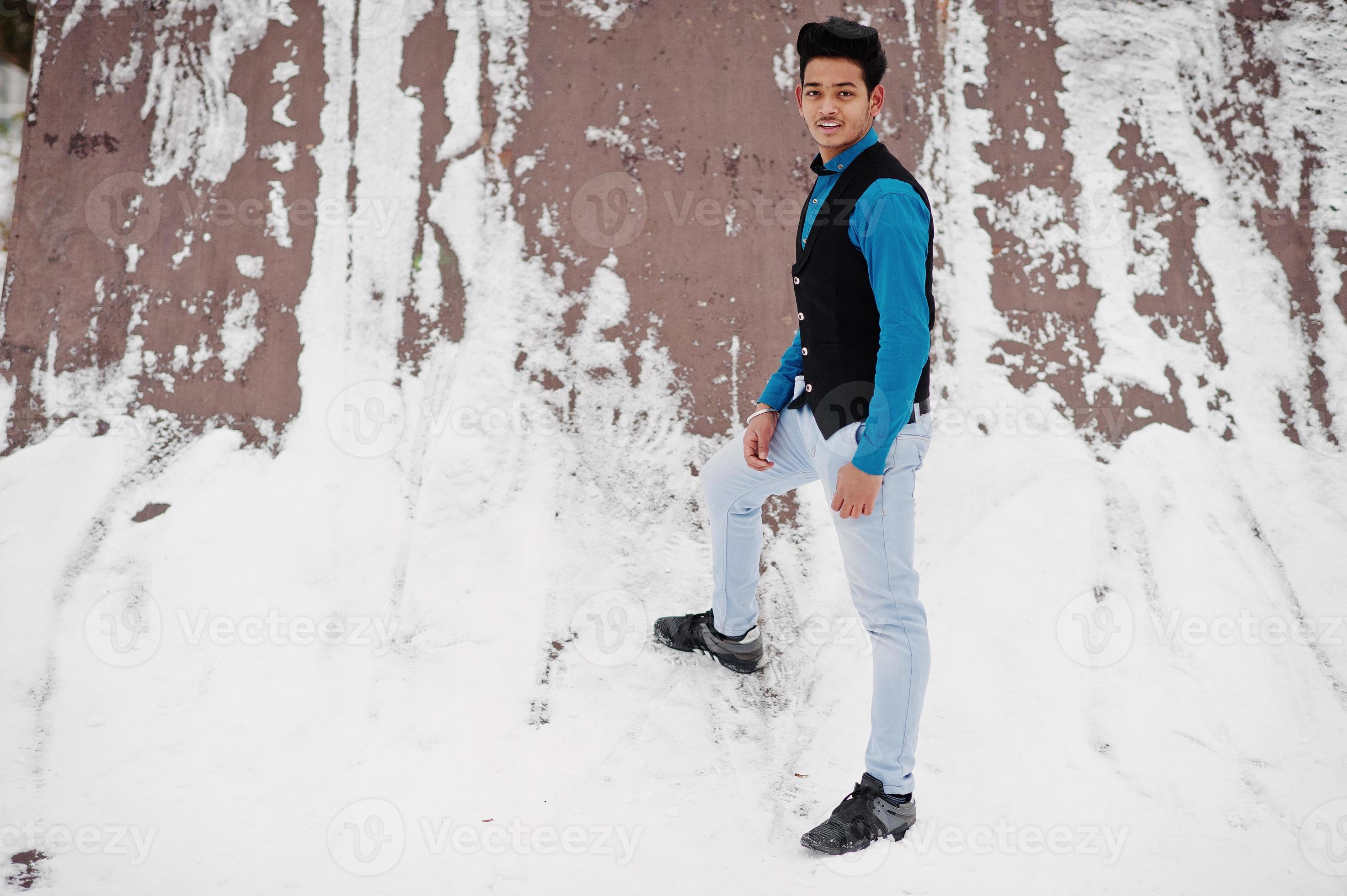 un joven indio casual con camisa azul y chaleco negro posó en el día de  invierno. 10573387 Foto de stock en Vecteezy