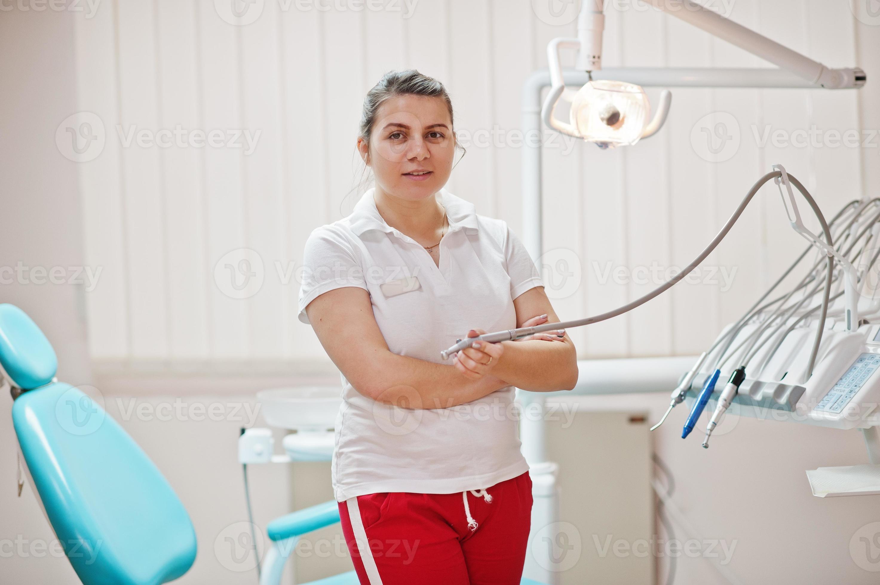 Portrait Of Female Dentist Woman Crossed Arms Standing In Her Dentistry Office Near Chair