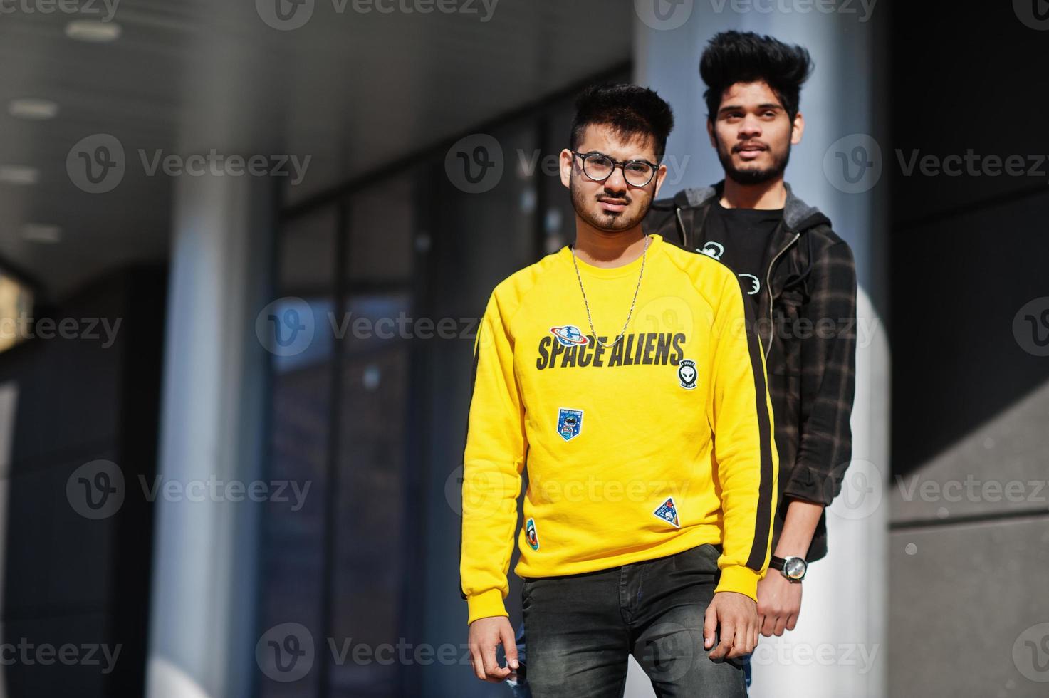 Two asian guys posed against new modern building. photo