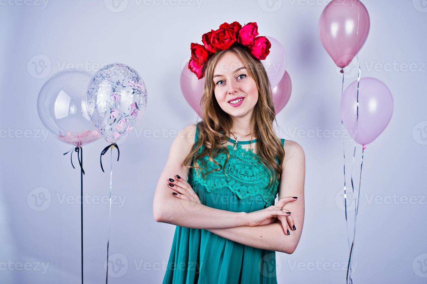 Happy girl in green turqoise dress and wreath with colored balloons isolated on white. Celebrating birthday theme. photo