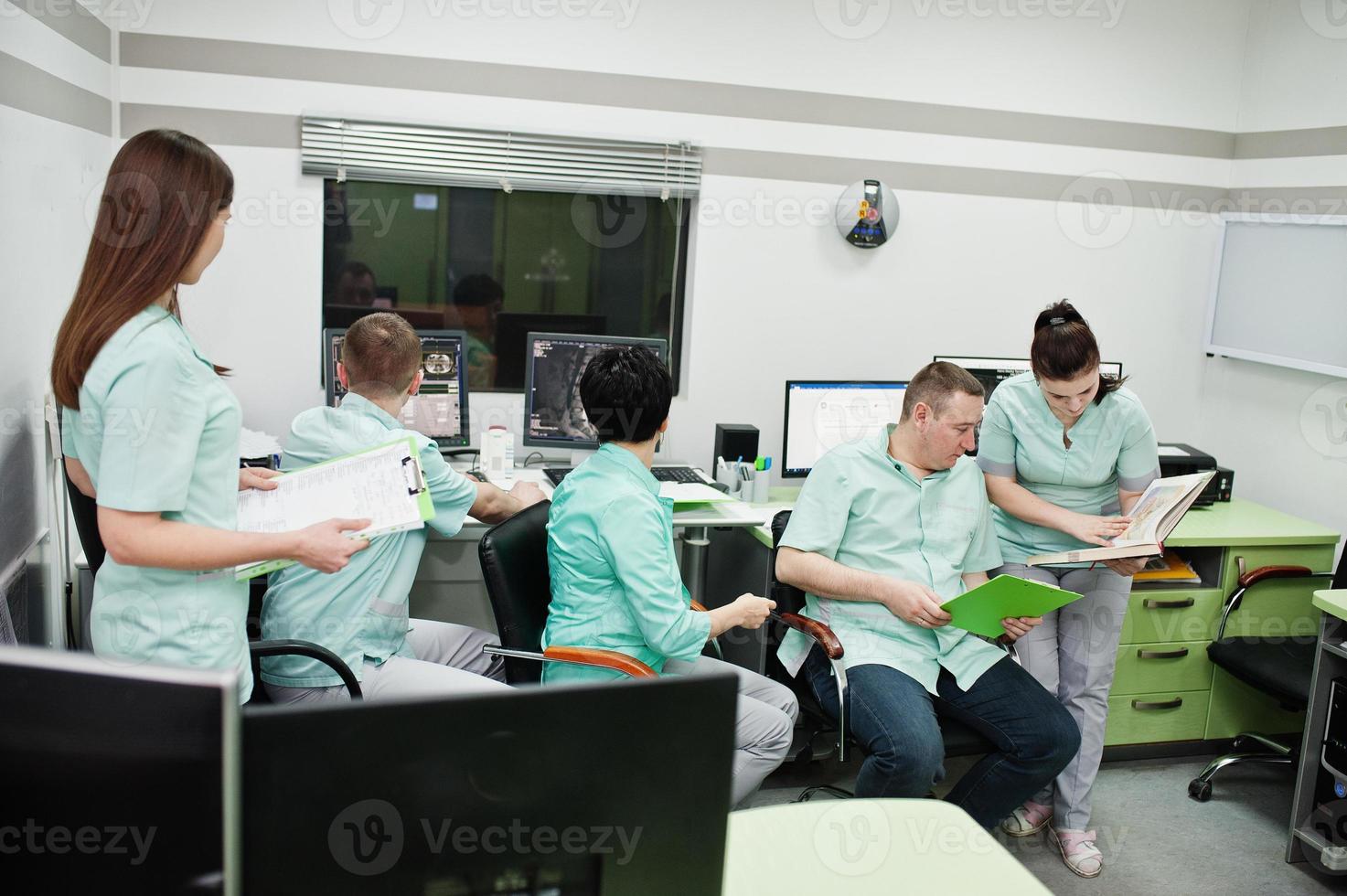 Medical theme.Observation room with a computer tomograph. The group of doctors meeting in the mri office at diagnostic center in hospital. photo