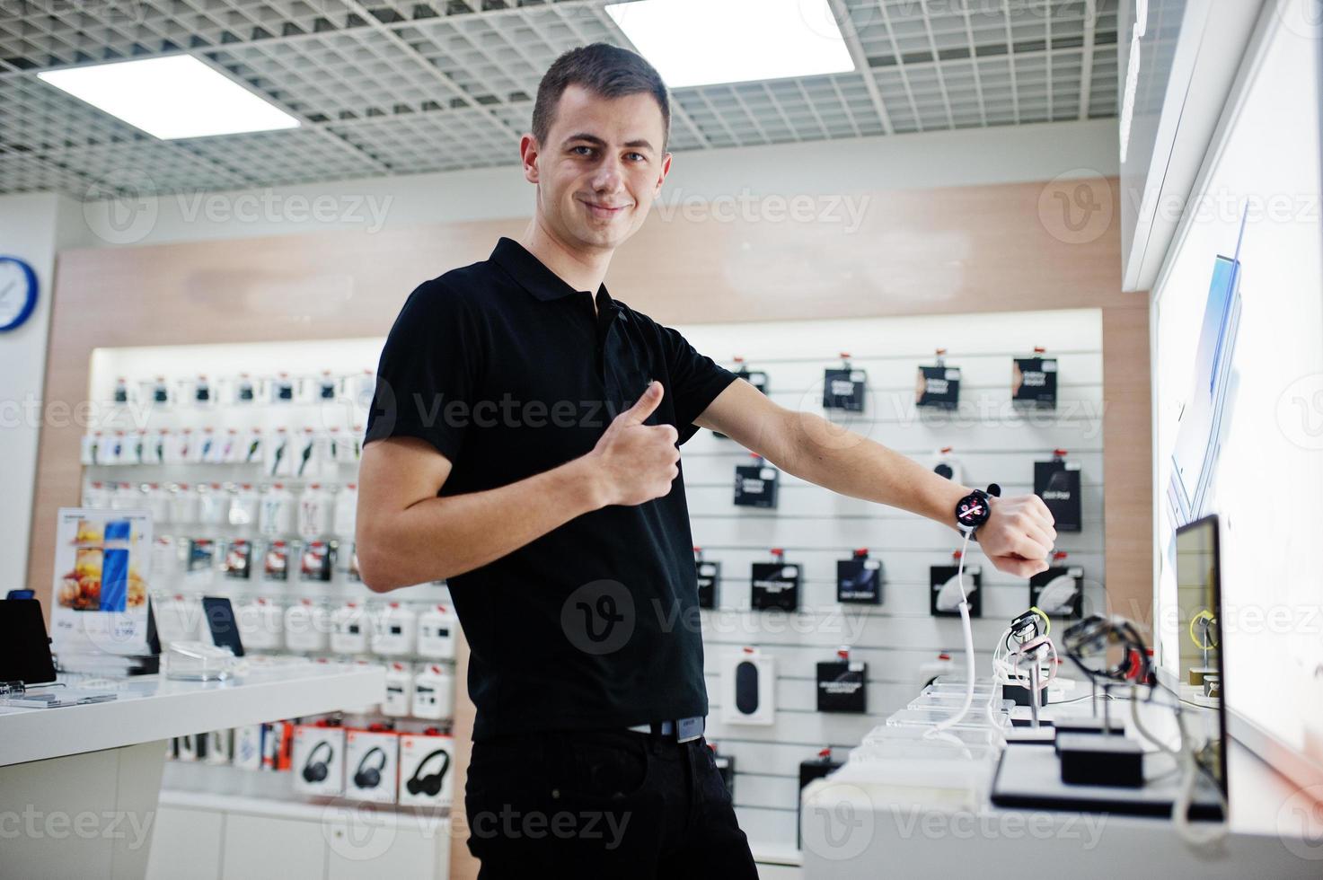 Seller man mobile phone professional consultant in tech store or shop check new smart watches. photo