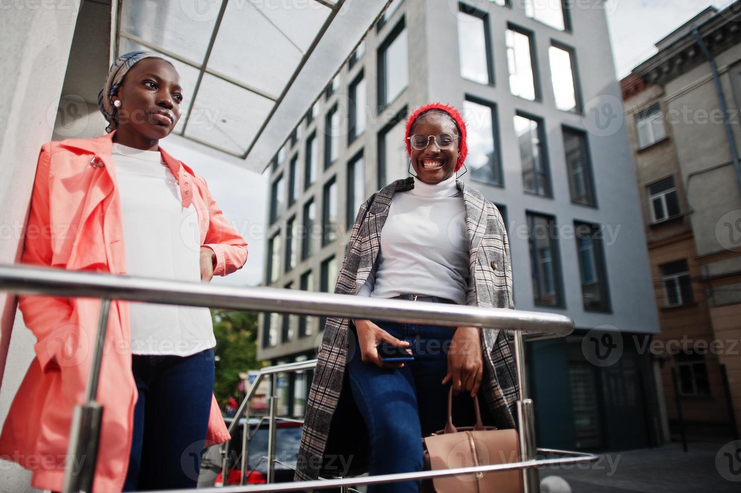 Two young modern fashionable, attractive, tall and slim african muslim womans in hijab or turban head scarf and coat posed. photo