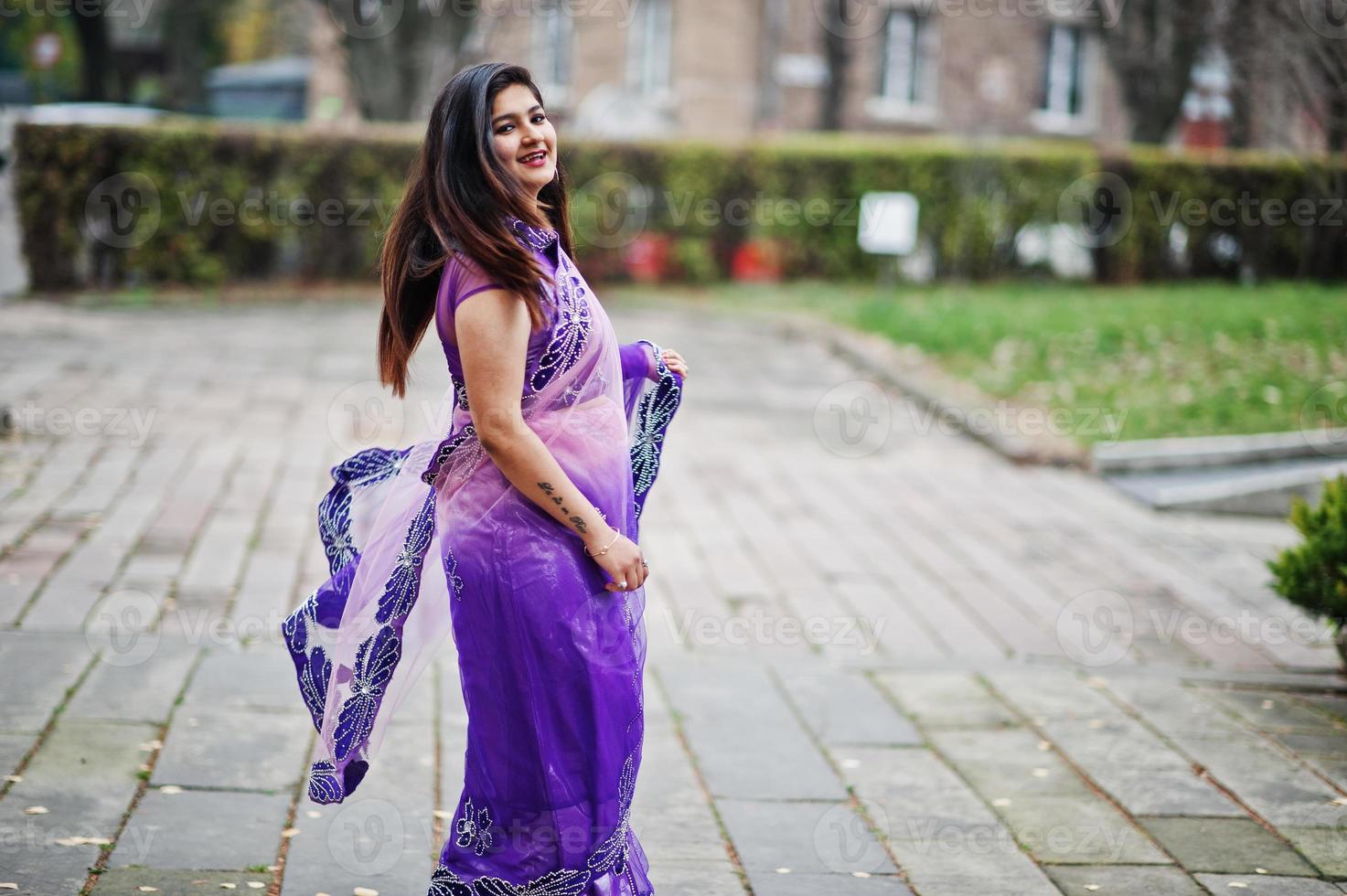 Indian hindu girl at traditional violet saree posed at autumn street. photo