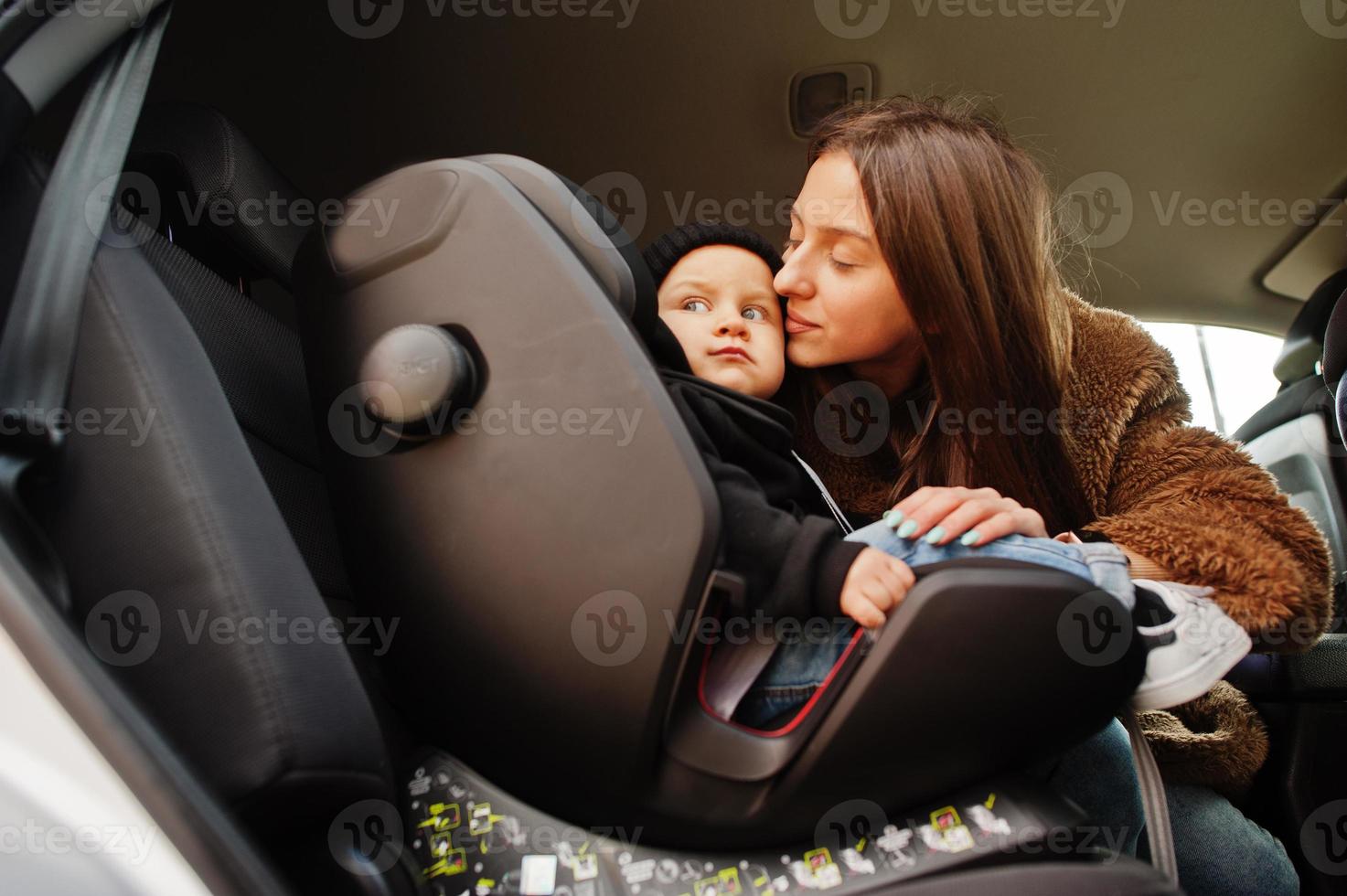 joven madre e hijo en coche. asiento de bebé en silla. concepto de conducción segura. foto