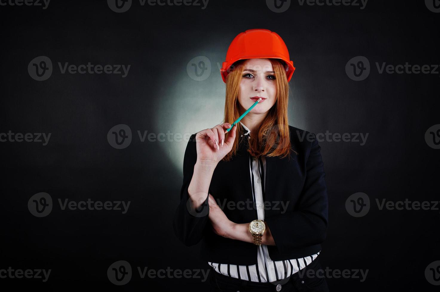 Engineer woman in orange protect helmet with pensil. photo