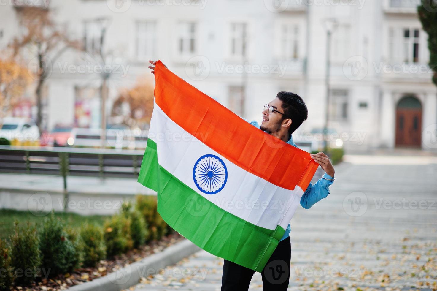 estudiante indio del sur de asia con bandera india posada al aire libre. foto