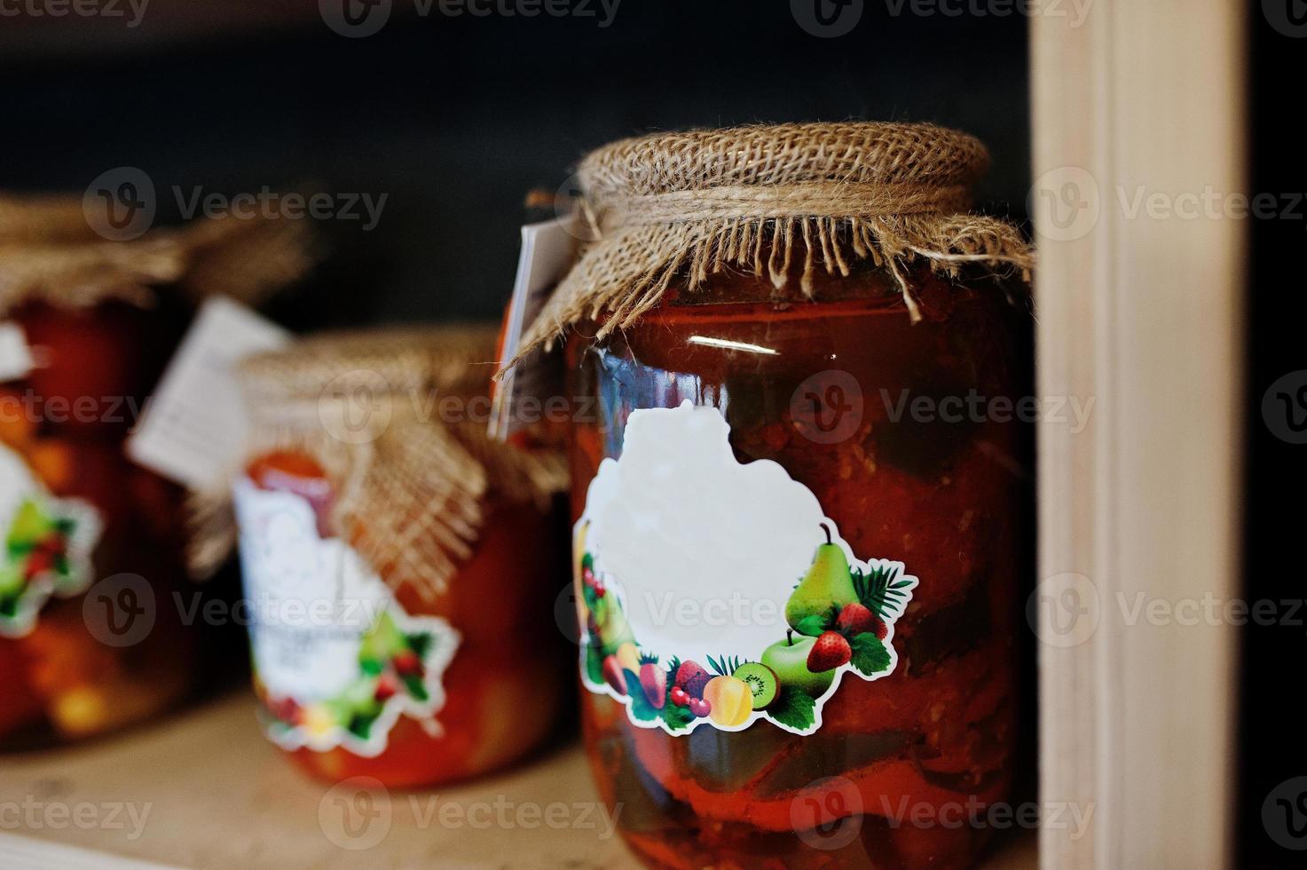 Glass jars with different kinds of jam and berries of a supermarket shelves or grocery store. Homemade canning products. Made with love. photo