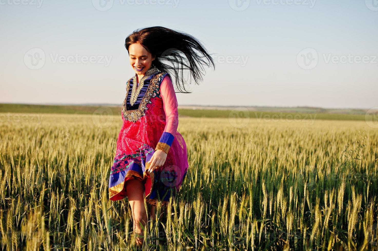 Tender indian girl in saree, with violet lips make up posed at field in sunset. Fashionable india model. photo