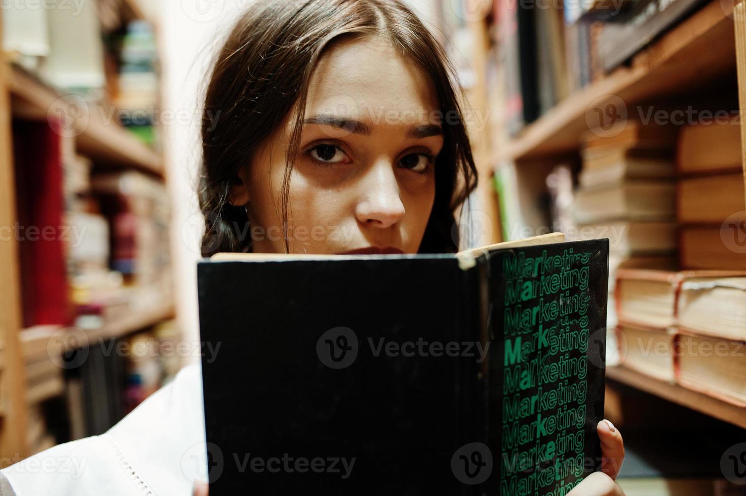 Girl with pigtails in white blouse at old library. photo