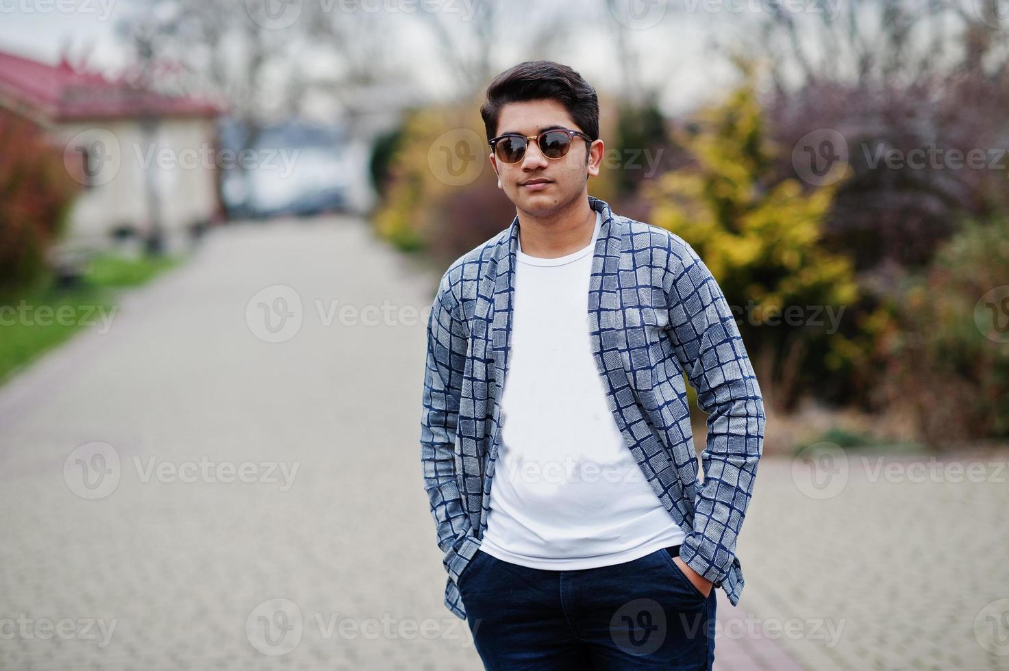 Stylish indian young man at sunglasses wear casual posed outdoor. photo