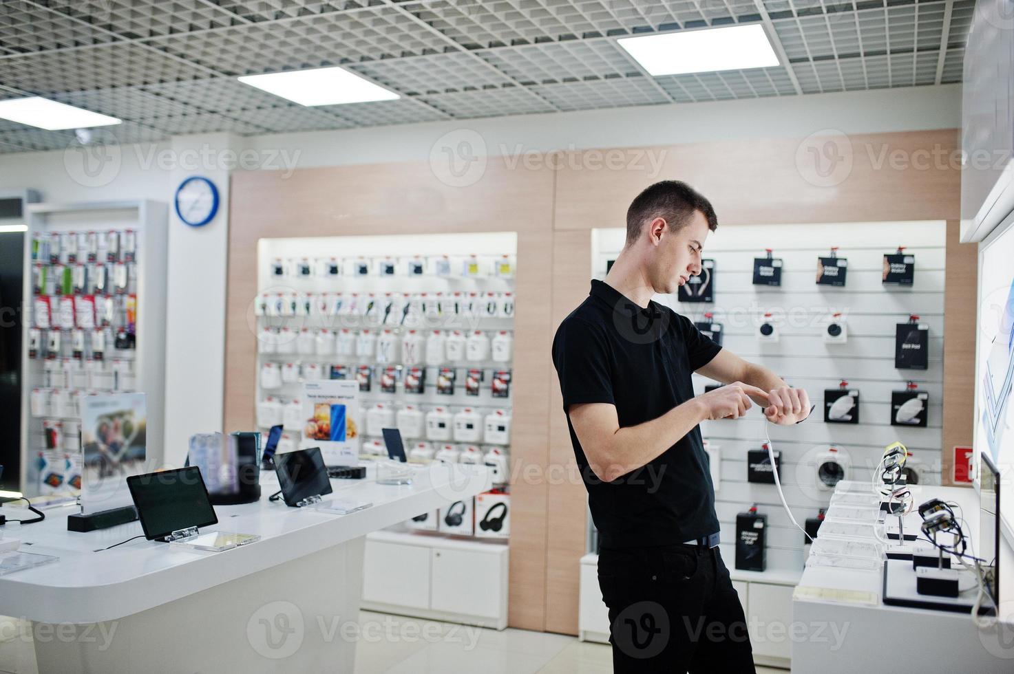 Seller man mobile phone professional consultant in tech store or shop check new smart watches. photo