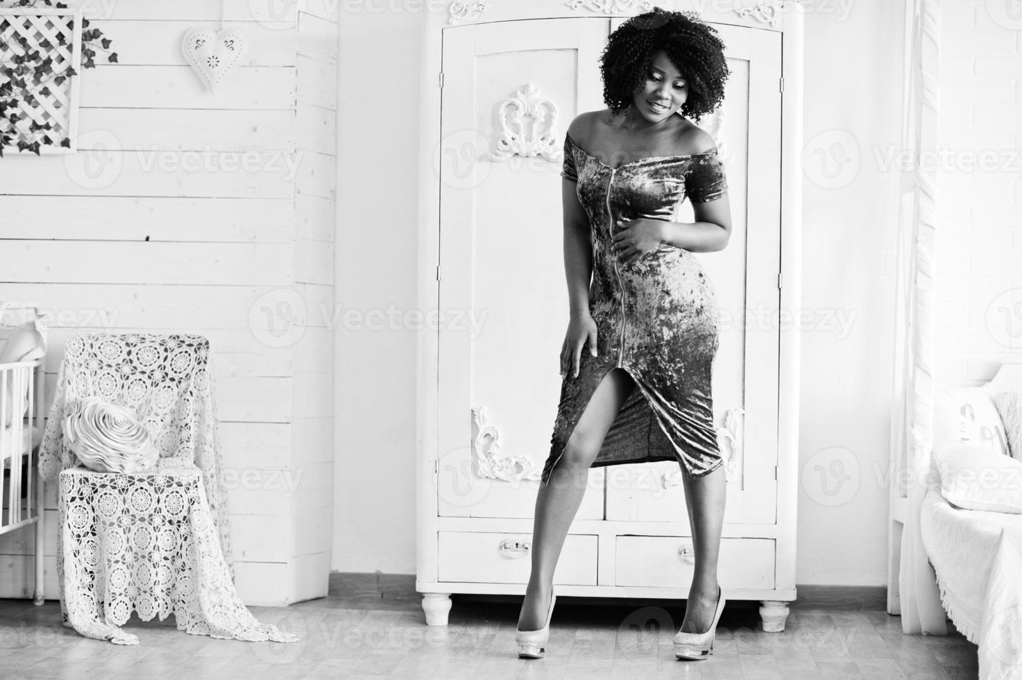 Afican american women in brilliant glitter sequins turqoise dress posed at white room against an old wardrobe. photo