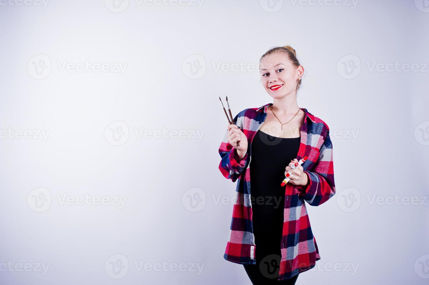 Beautiful woman artist painter with brushes posing in studio isolated on white. photo
