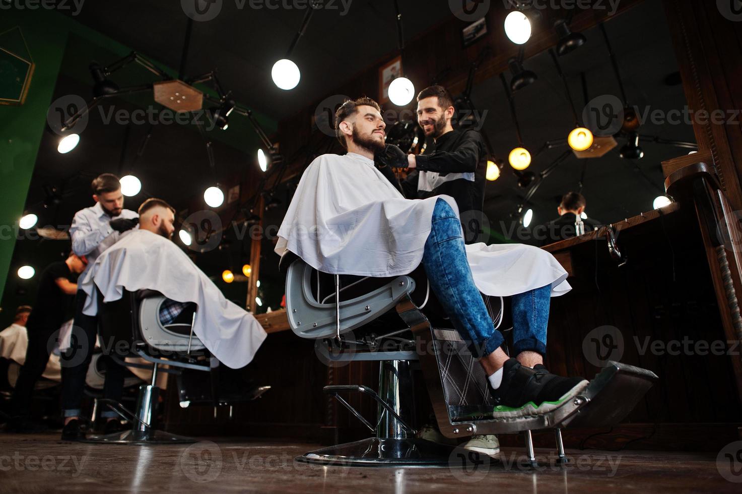 Handsome bearded man at the barbershop, barber at work. photo