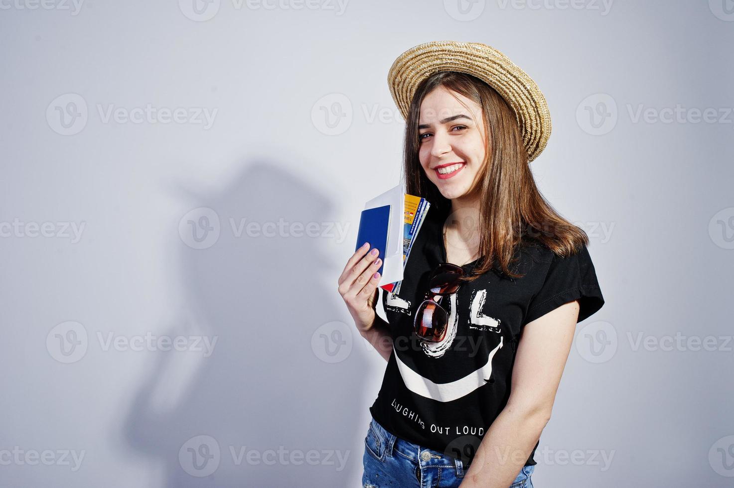 Girl tourist with passport, wear in lol shirt, shorts and hat isolated on white. photo