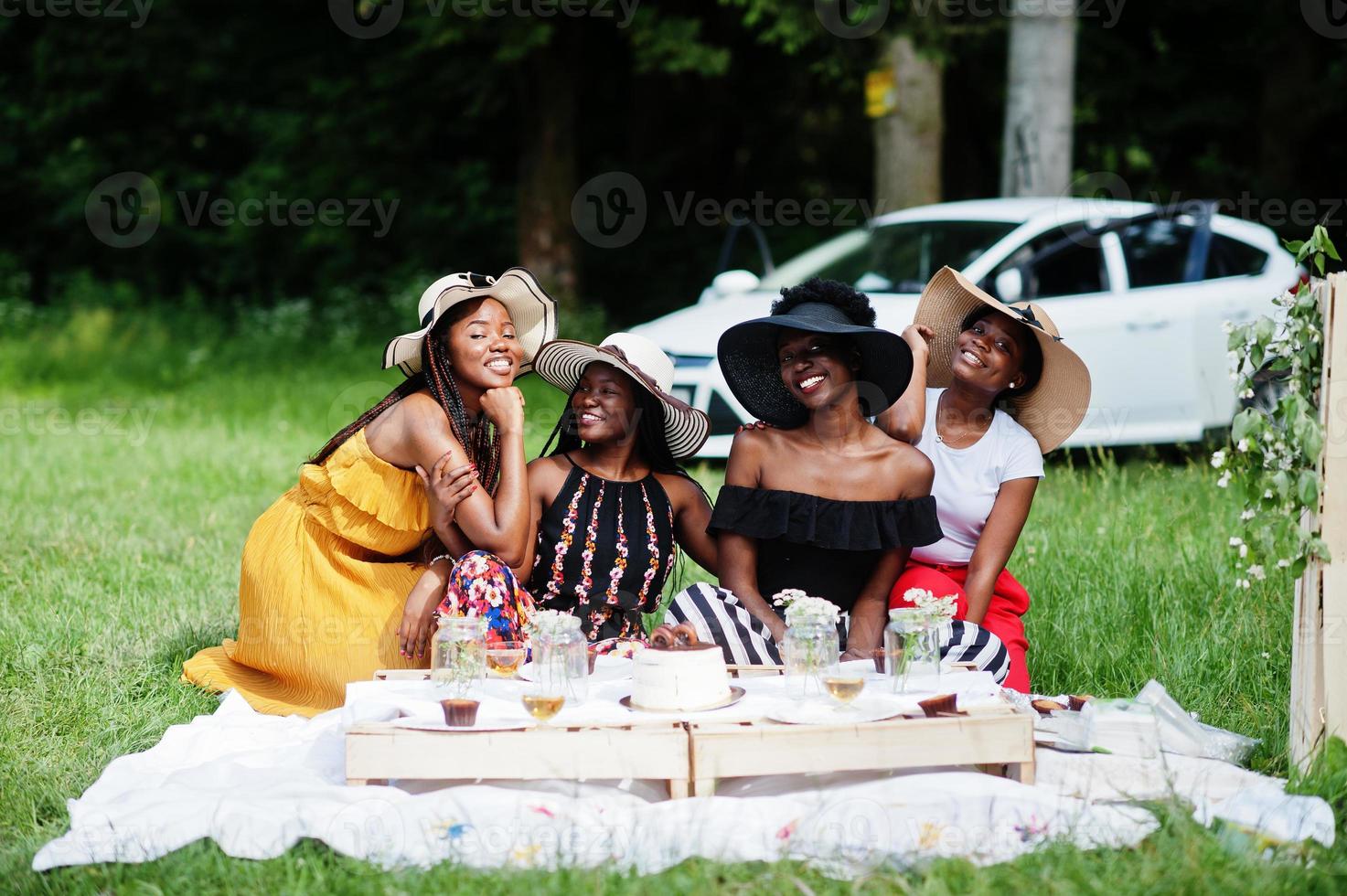 Group of african american girls celebrating birthday party and clinking glasses outdoor with decor. photo