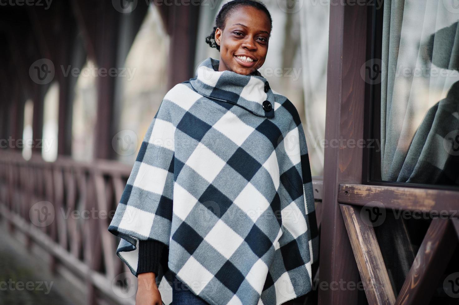 African woman in checkered cape posed outdoor. photo