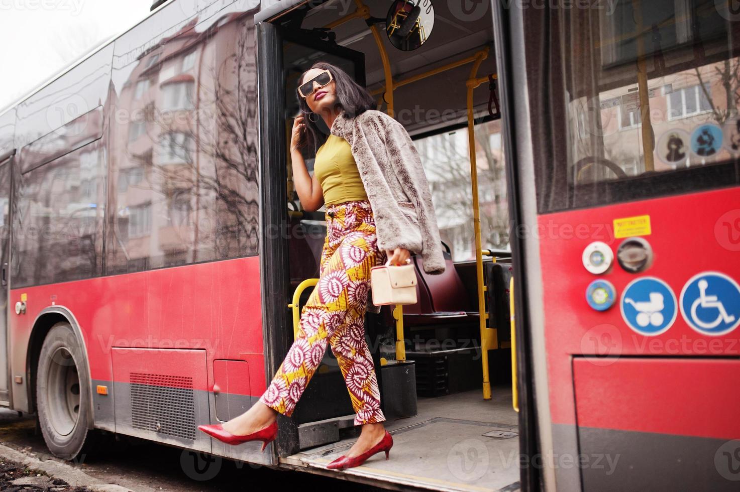 Young stylish african american woman in modern sunglasses riding on a bus. photo
