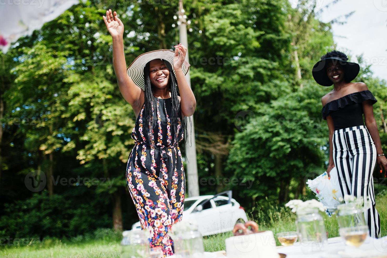 Group of african american girls celebrating birthday party and having fun with pillows outdoor with decor. photo