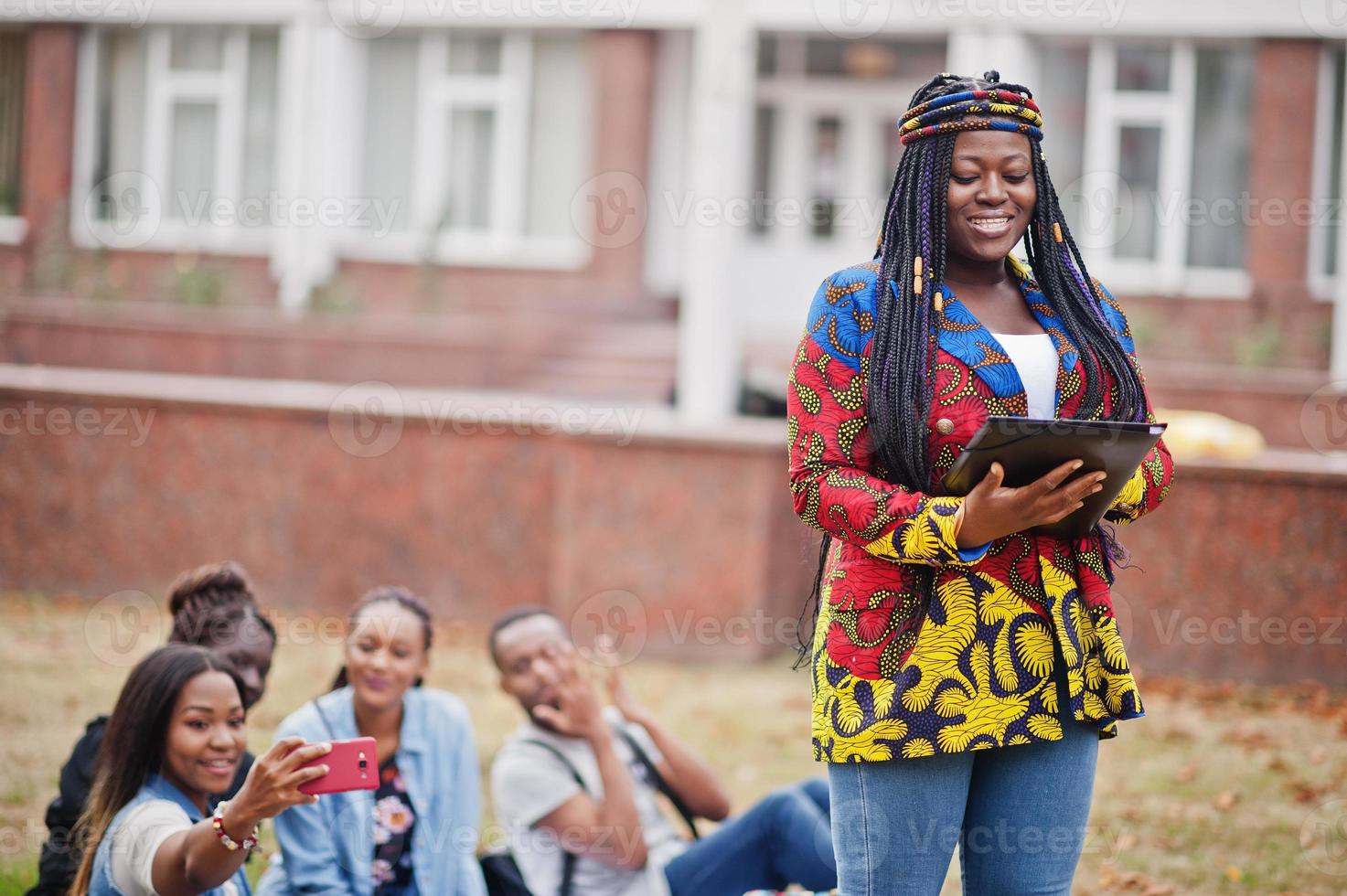 grupo de cinco estudiantes universitarios africanos que pasan tiempo juntos en el campus en el patio de la universidad. amigos negros afro estudiando. tema de la educación foto