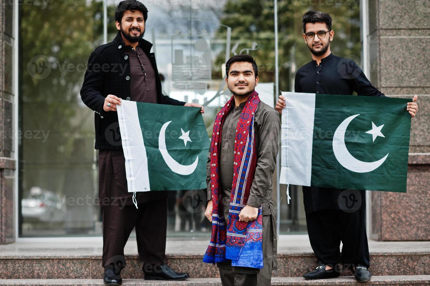 Group of pakistani man wearing traditional clothes salwar kameez or kurta with Pakistan flags. photo