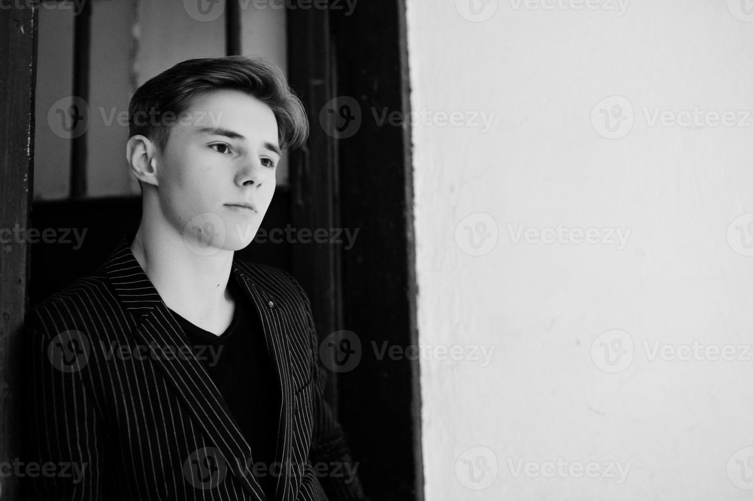 Young stylish macho boy in black jacket posed outdoor of street. Amazing model man. photo