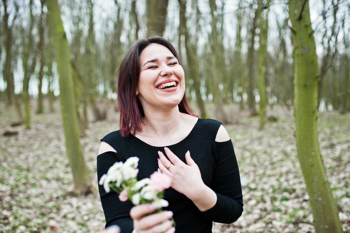 Portrait of brunette girl in black dress at spring wood. photo